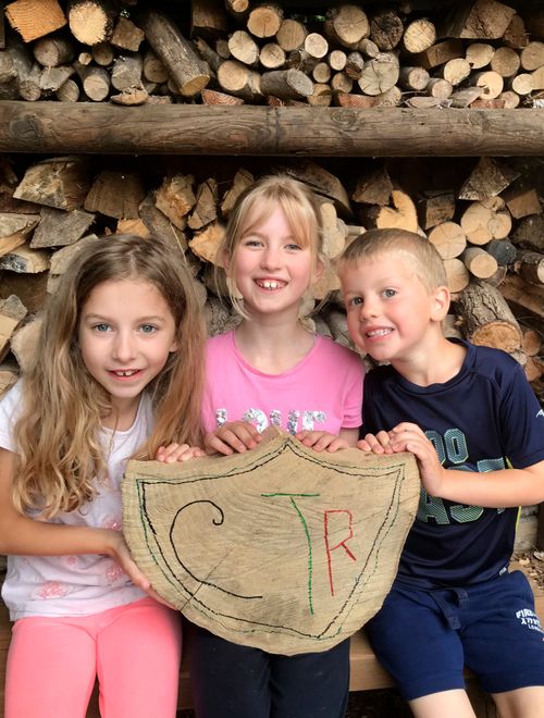 three girls holding a wooden CTR shield