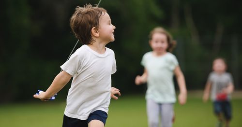 A boy runs through a park.