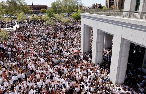 Folle di giovani adulti inondano la piazza del Centro delle conferenze prima dell’inizio della riunione mondiale del 15 maggio 2022.