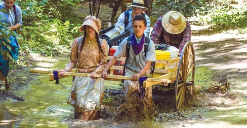 youth pulling handcart through mud