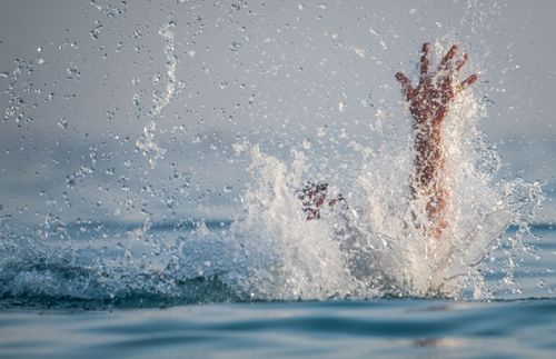 a hand reaching out of water