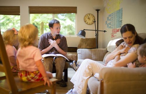 man with hands crossed teaching family