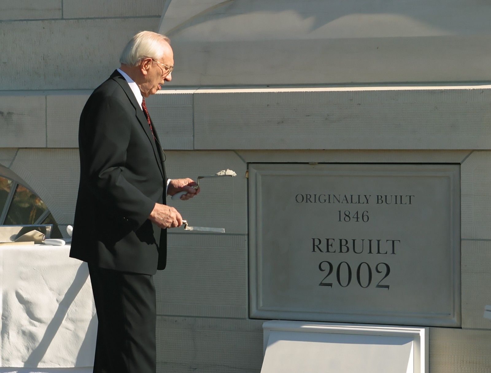 Gordon B. Hinckley applying mortar at the cornerstone ceremony during the dedication of the Nauvoo Illinois Temple.