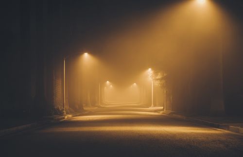 calle con niebla y postes de luz