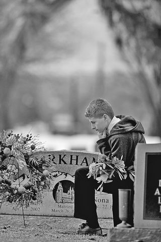 Boy with flowers at grave site