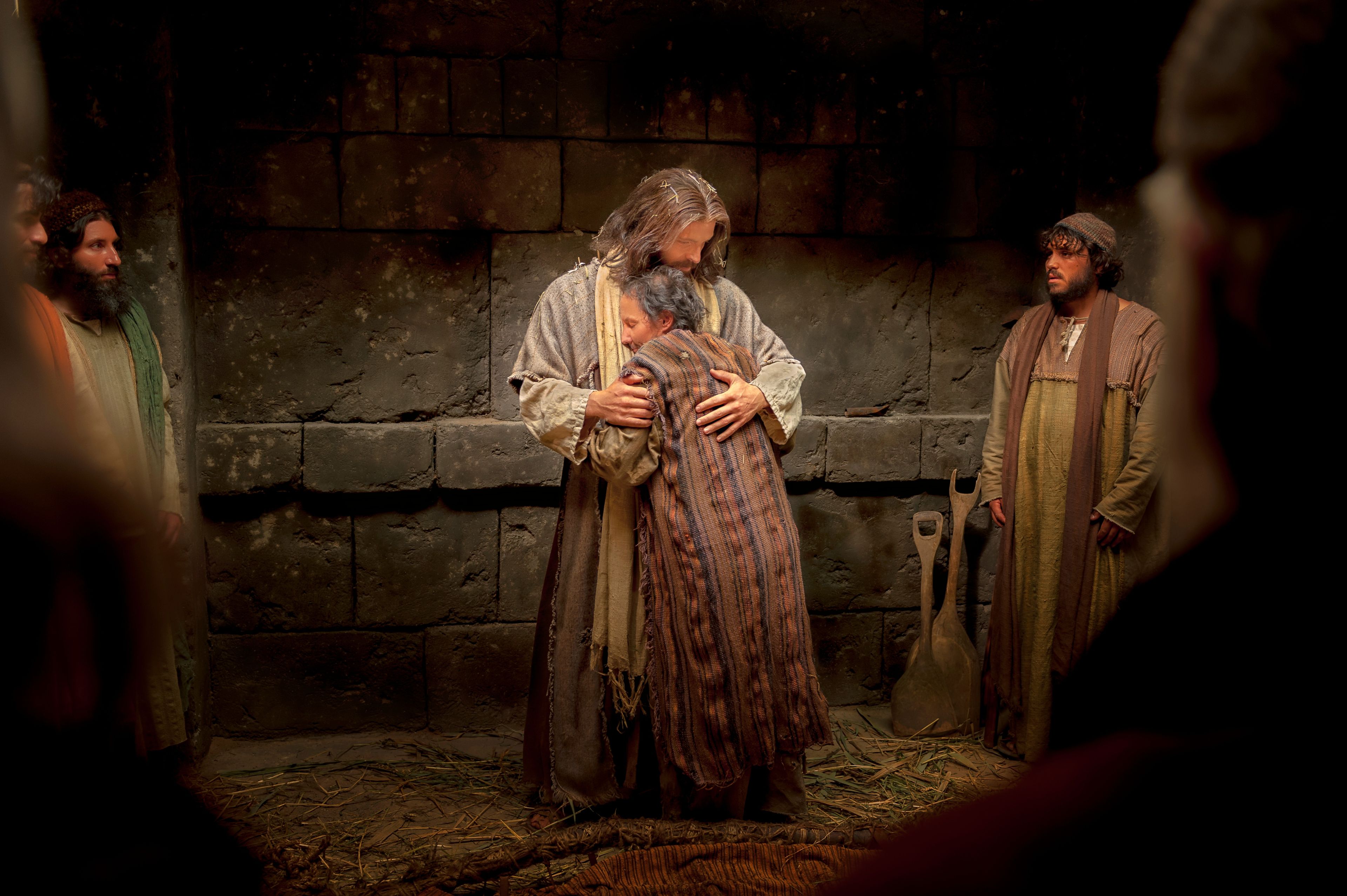 A man standing and embracing Christ after being healed.
