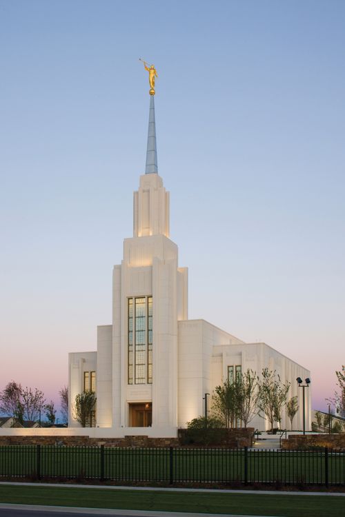 The entrance of the Twin Falls Idaho Temple, with trees on either side and the fence in front.