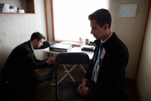 two missionaries kneeling in prayer