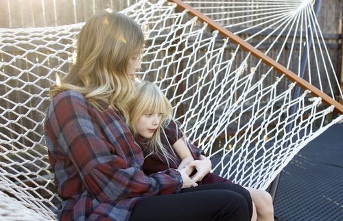 mother and daughter sitting in hammock