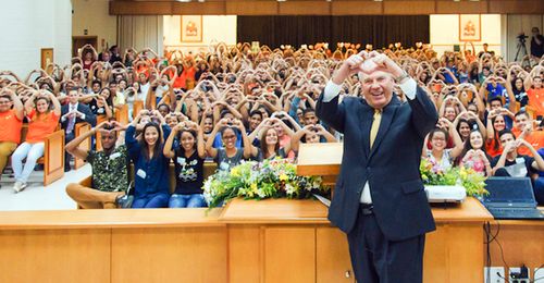 Elder Ronald A. Rasband making sign of heart at meeting in Brazil