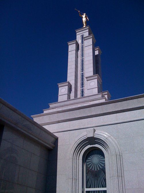 The spire and angel Moroni on the Lubbock Texas Temple, set against a deep blue sky.