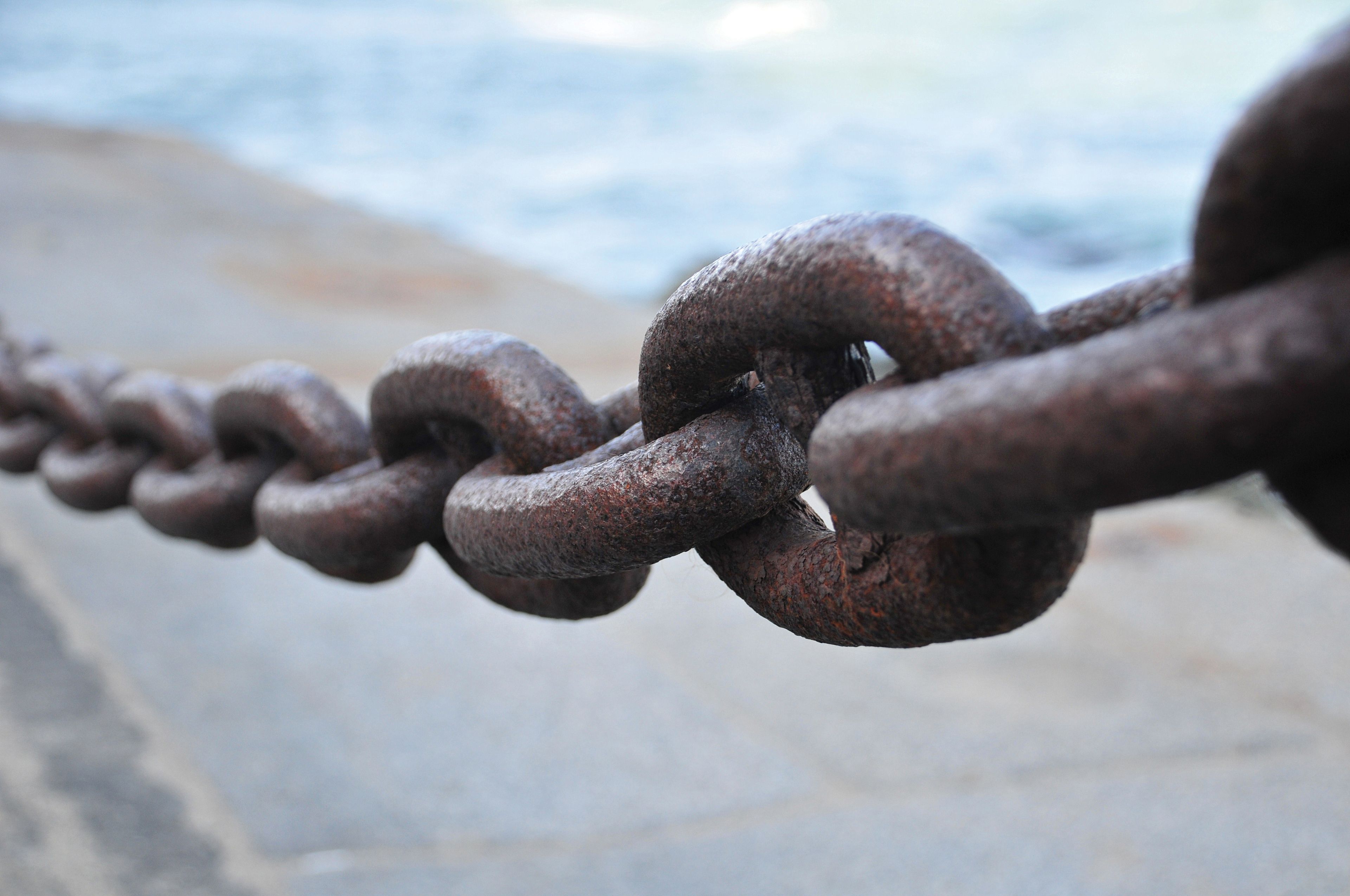 A metal chain hanging near the seashore.