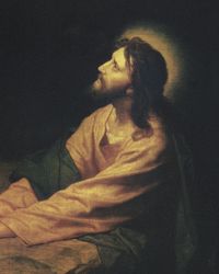 Jesus Christ kneeling as He prays and atones in the Garden of Gethsemane. Christ is depicted wearing red and blue robes. He has His hands clasped and is resting them on a large rock. A small stream of light coming through the darkened and cloudy background shines on the face of Christ. Light emanates around Christ's head.