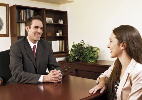 A young woman seated across the desk from her bishop.