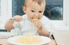 infant eating noodles