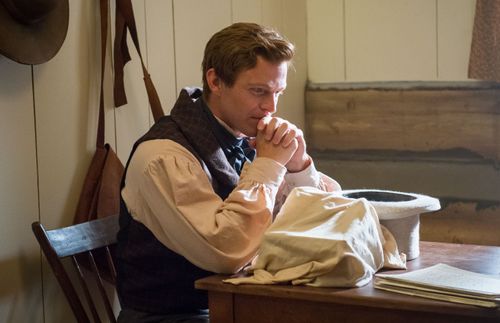 Joseph Smith sitting at a table