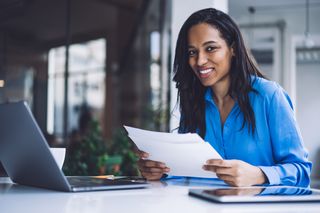 Black businesswoman doing paperwork in office<br>