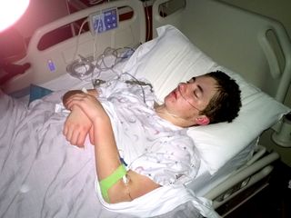 young man lying in hospital bed