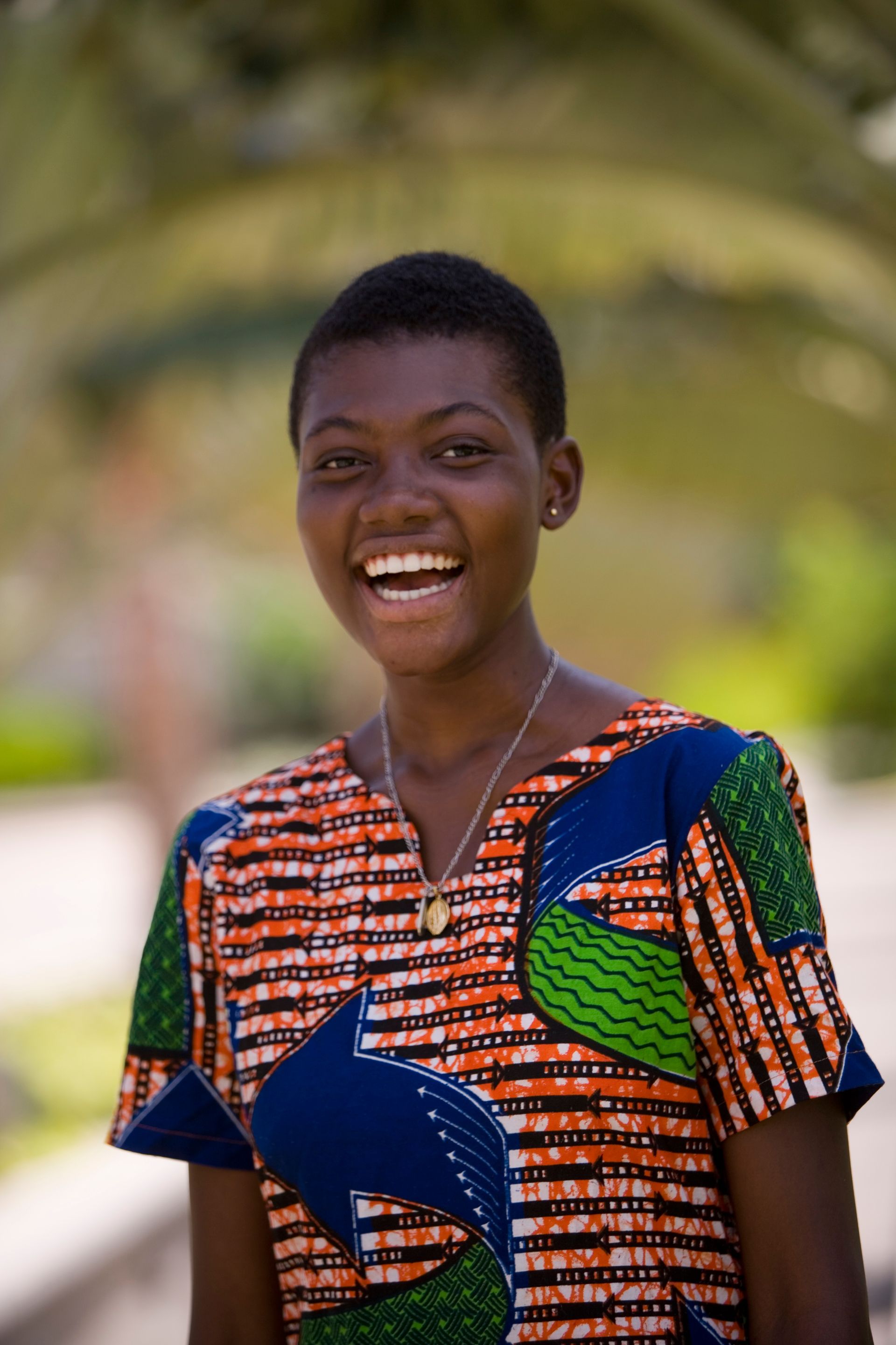 A portrait of a young woman from Ghana laughing.