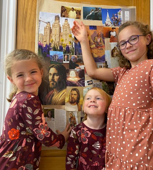 Three girls in front of pictures of Jesus