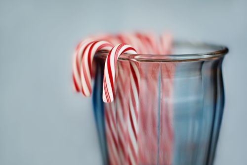 A photograph of candy canes in a glass jar.
