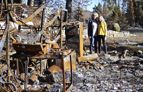 mother and daughter look through home ruined by fire