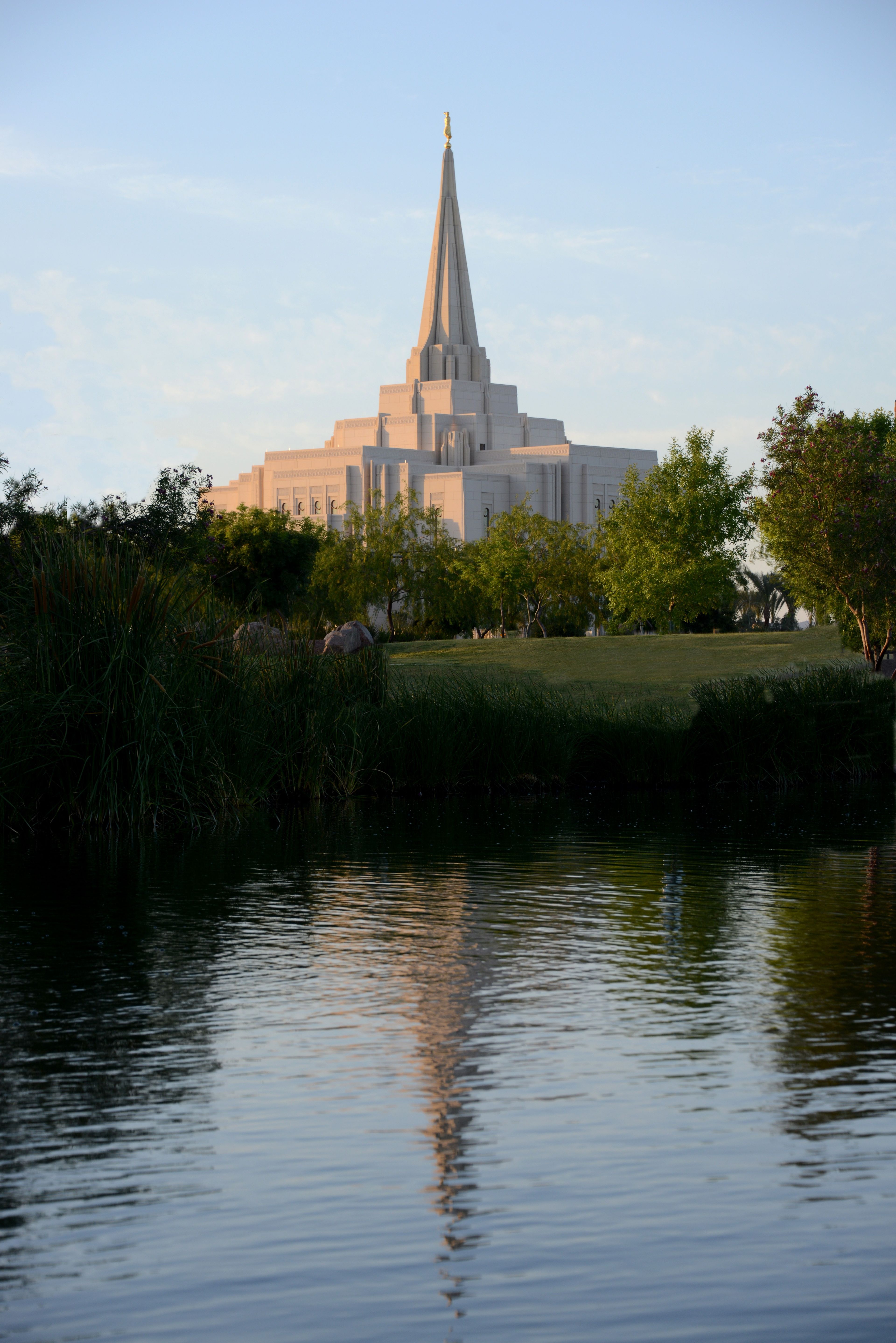 The reflection of the Gilbert Arizona Temple is seen in a nearby body of water.