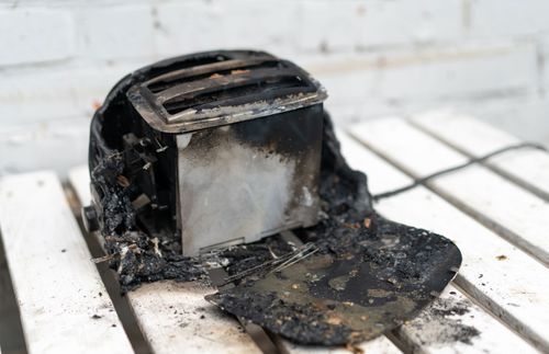 burning toaster with burnt bread