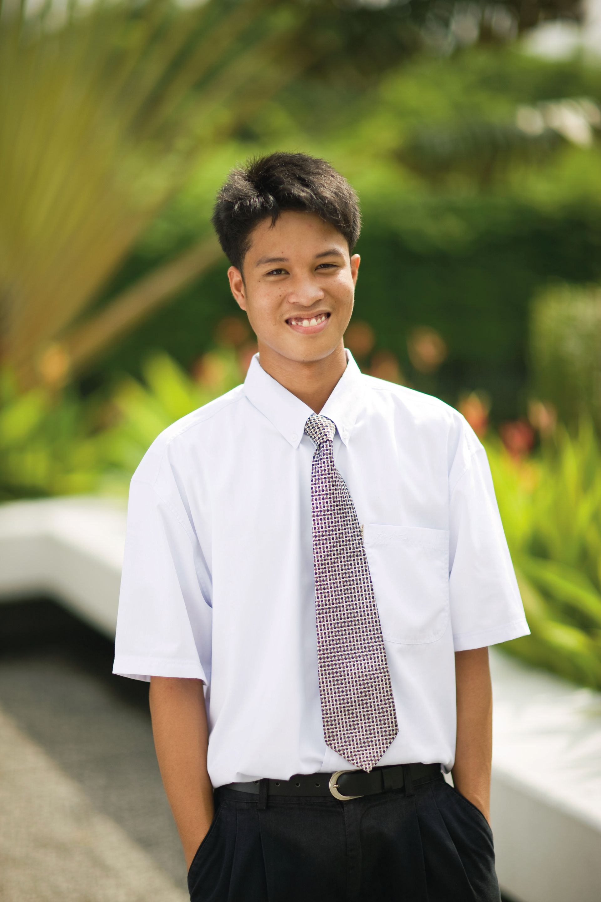 A portrait of a young man in the Philippines wearing Sunday clothes.