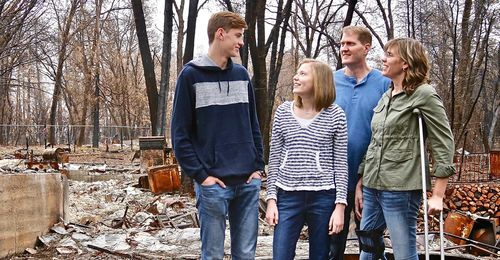 family at site of burned-down house