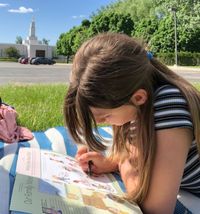 girl reading outside temple grounds