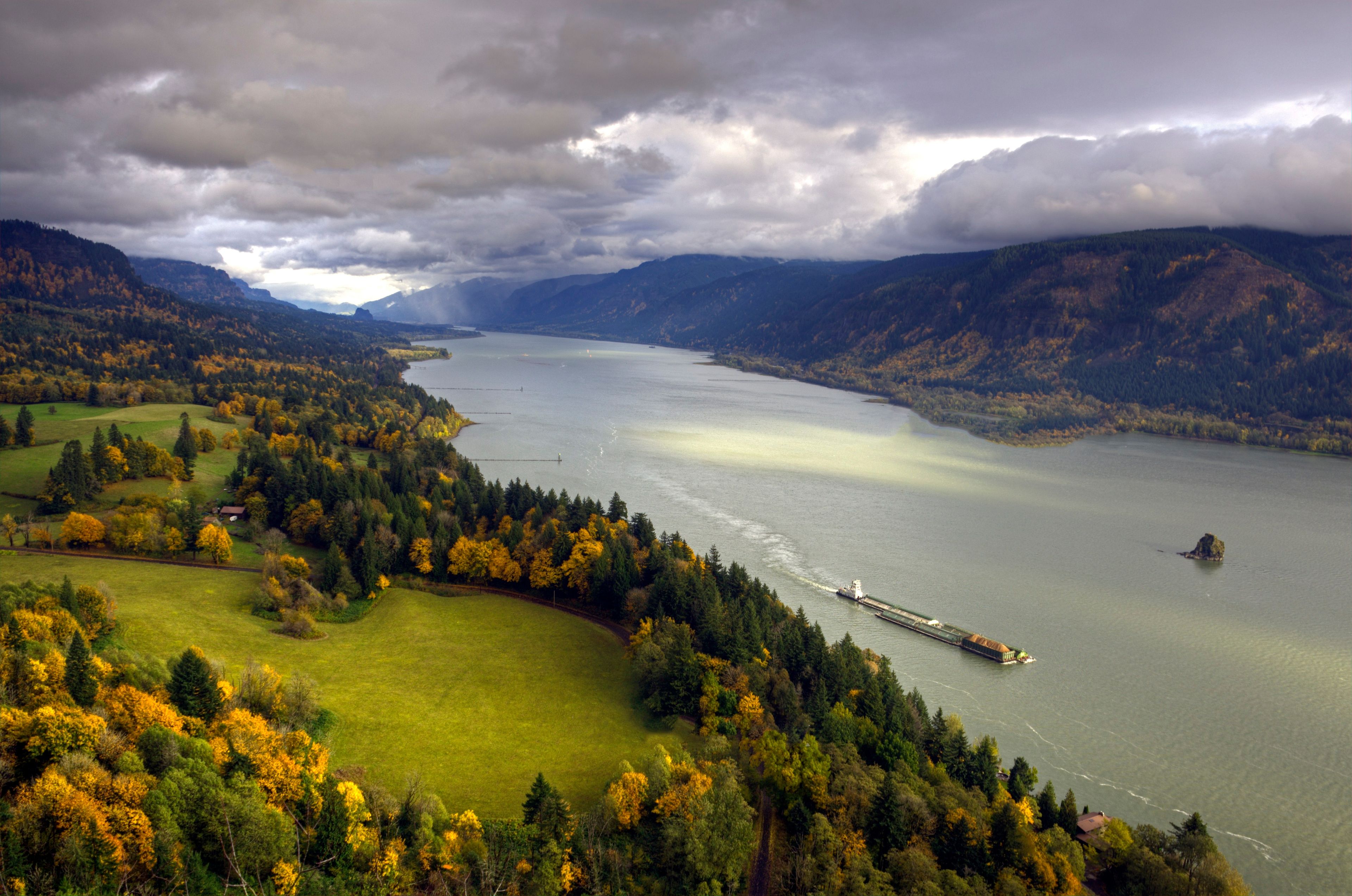 A barge floats down the Columbia River in autumn.