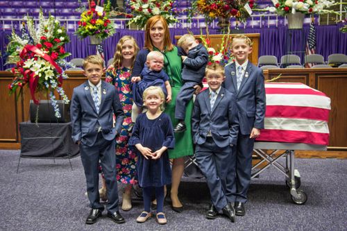 family of Brent Taylor stands in front of his coffin during funeral service