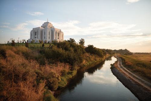 A view of the Meridian Idaho Temple and the Boise River at sunset.