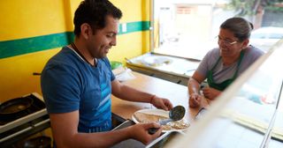 a young adult prepares food at a restaurant