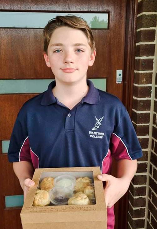 Light the world in Australia, Blake White holds a box full of scones that he made in his cooking class at school to a couple of his elderly neighbors.