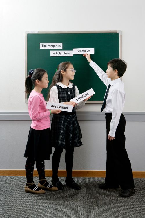 Primary children holding up word strips