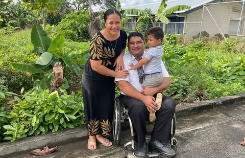 muž na invalidním vozíku s rodinou