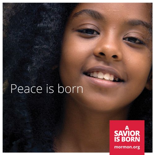 A close-up view of a smiling young woman with black hair, with the words “Peace is born.”