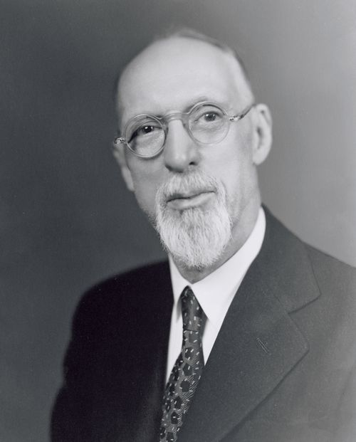 President George Albert Smith in a white shirt, dark suit, and spotted tie.