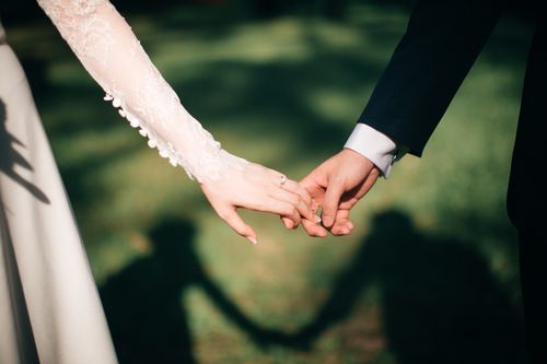 A bride and groom hold hands on their wedding day.