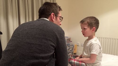 Sister Burton's son and grandson on a bed together.