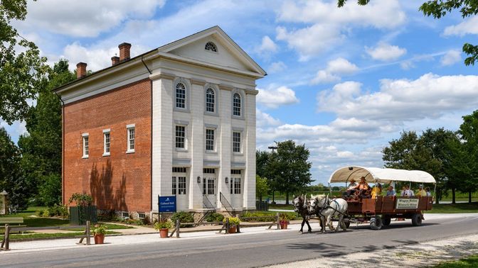 A three-story building with white stone on its front façade and red brick siding.