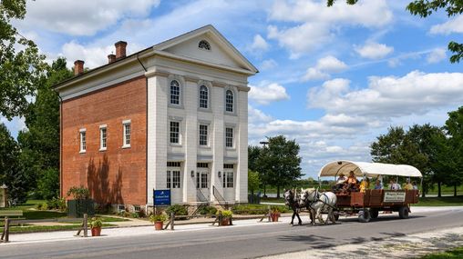 A three-story building with white stone on its front façade and red brick siding.