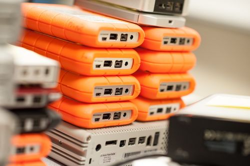 A stack of orange and gray external hard drives.