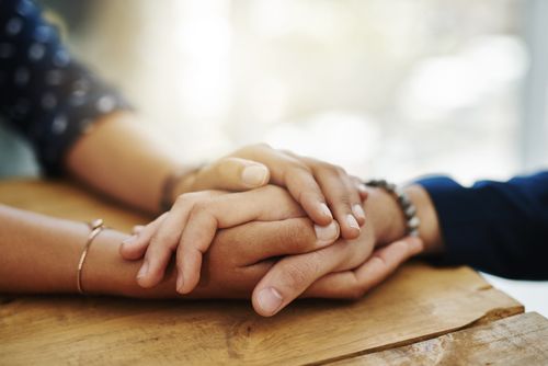 close-up of two people clasping hands