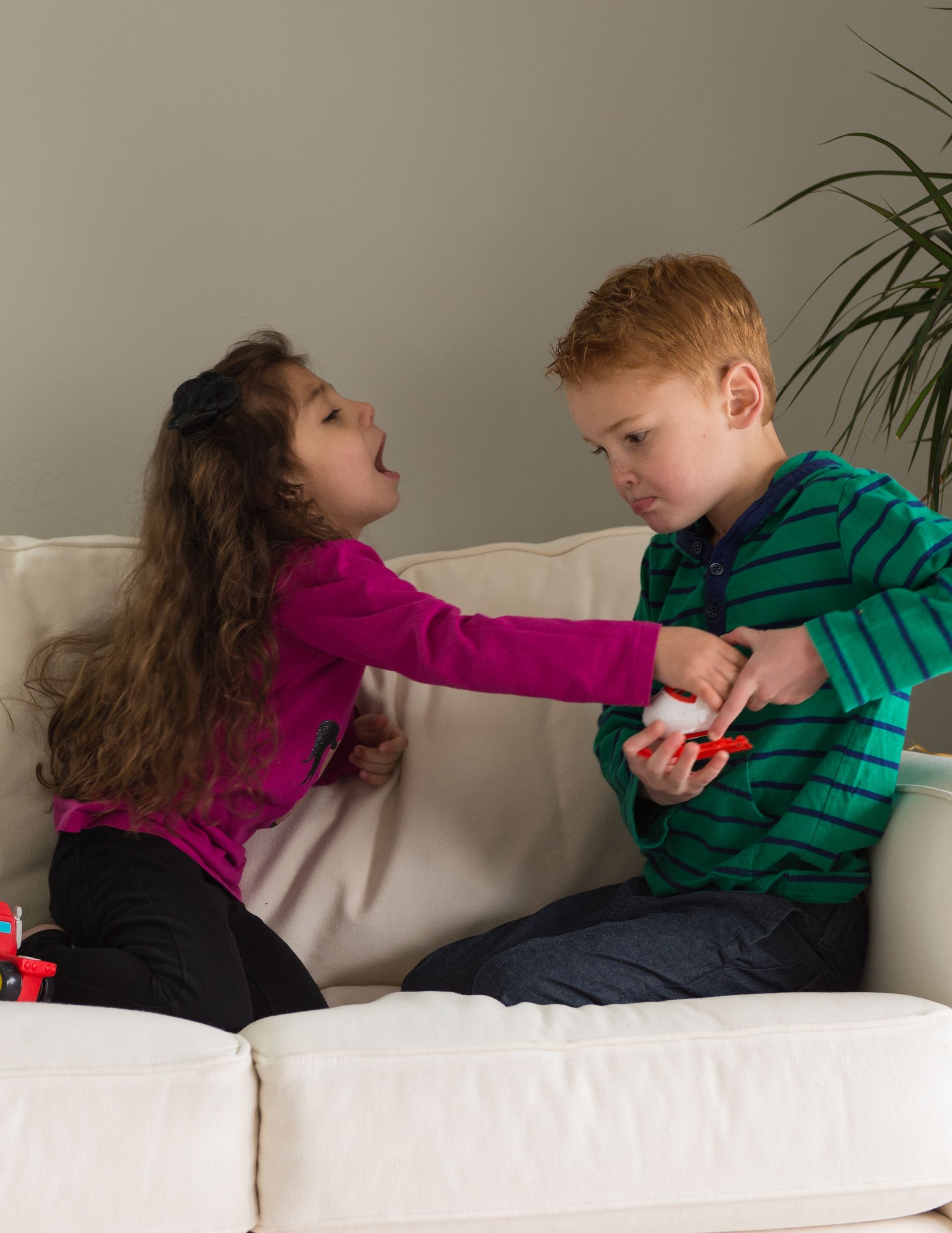 Two children fighting over toys.