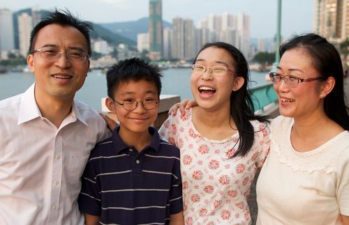 Family posing together on a street in Hong Kong.