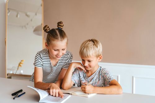 a sister and a brother at a table together