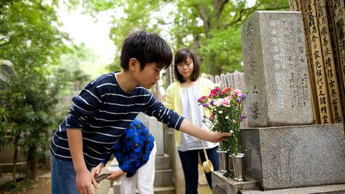 family putting flowers on grave